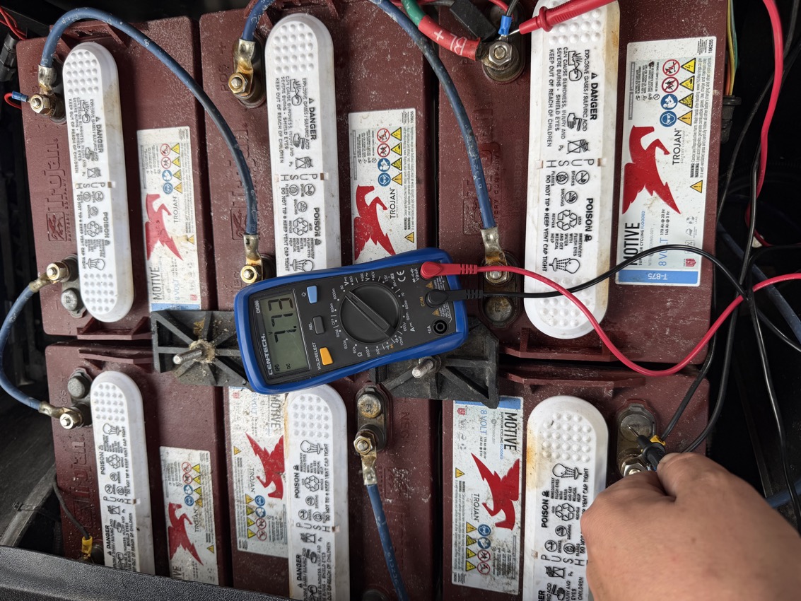 Before upgrade: Technician testing low voltage on Trojan batteries - golf cart battery diagnostic Broward
